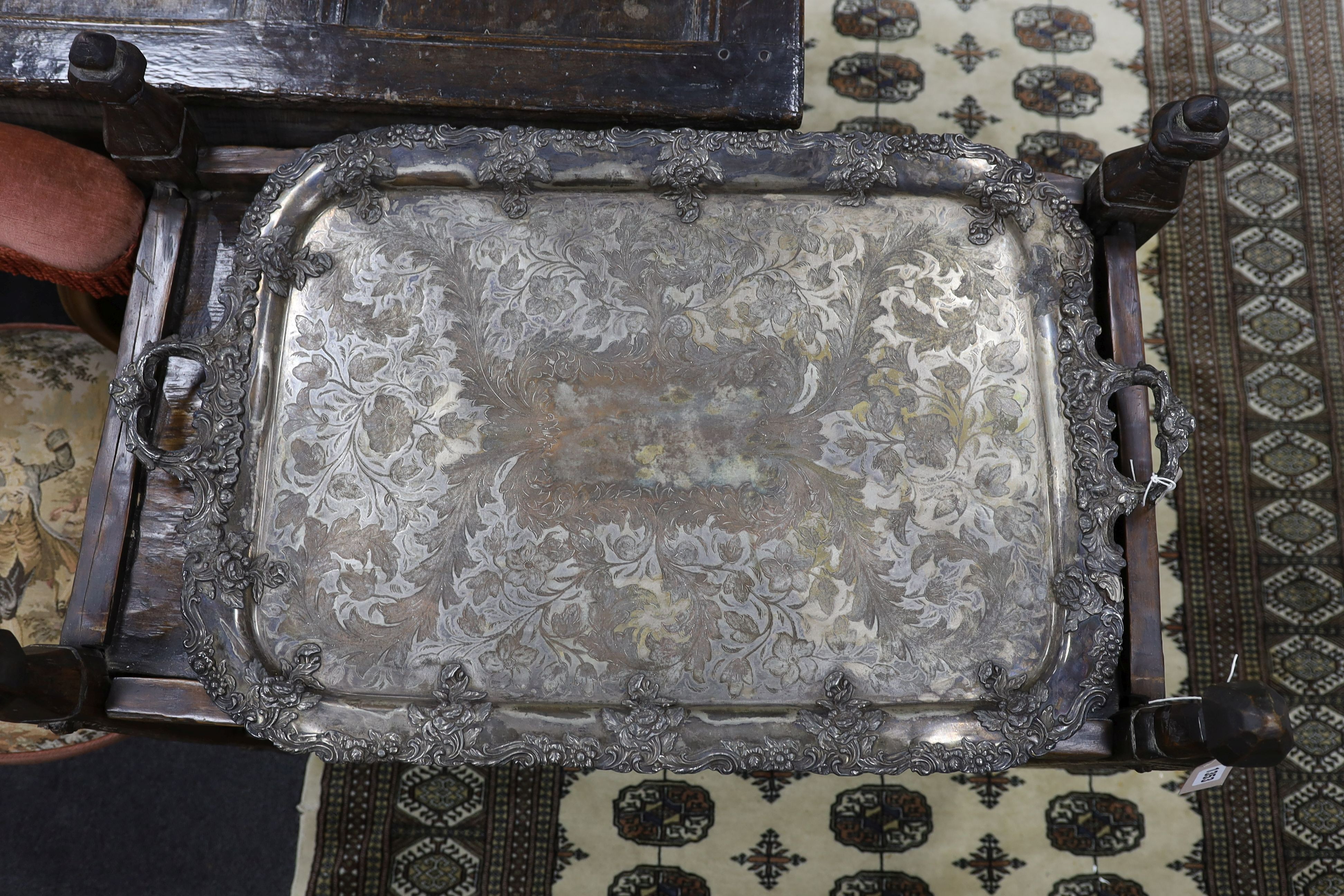 A large two handled silver plated tray with ornate floral edge, 87 cms wide.